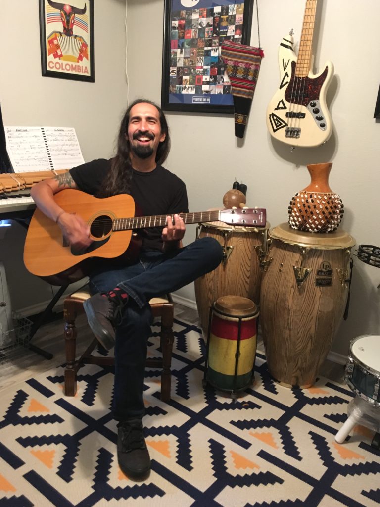 man playing guitar at home