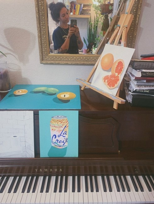 painted canvases in bright colors scattered across the top of a piano