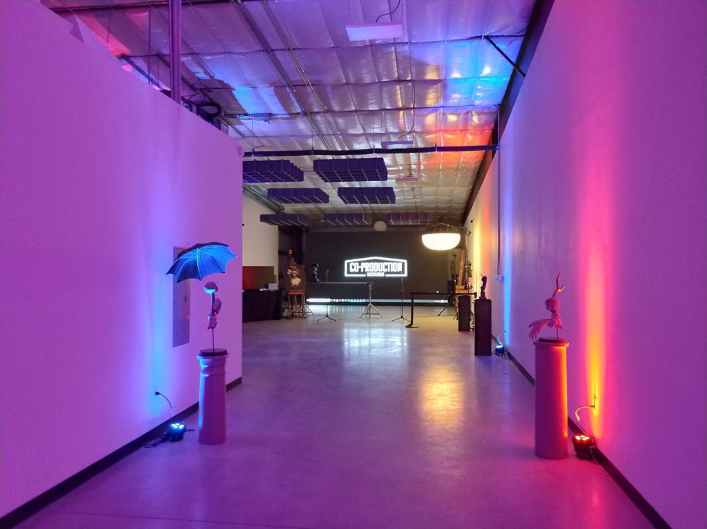 A huge LED wall at the end of a white warehouse studio.