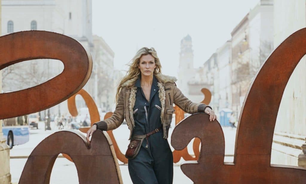 Mia stands in the middle of the LOVE HATE sculptures in the middle of a European city street