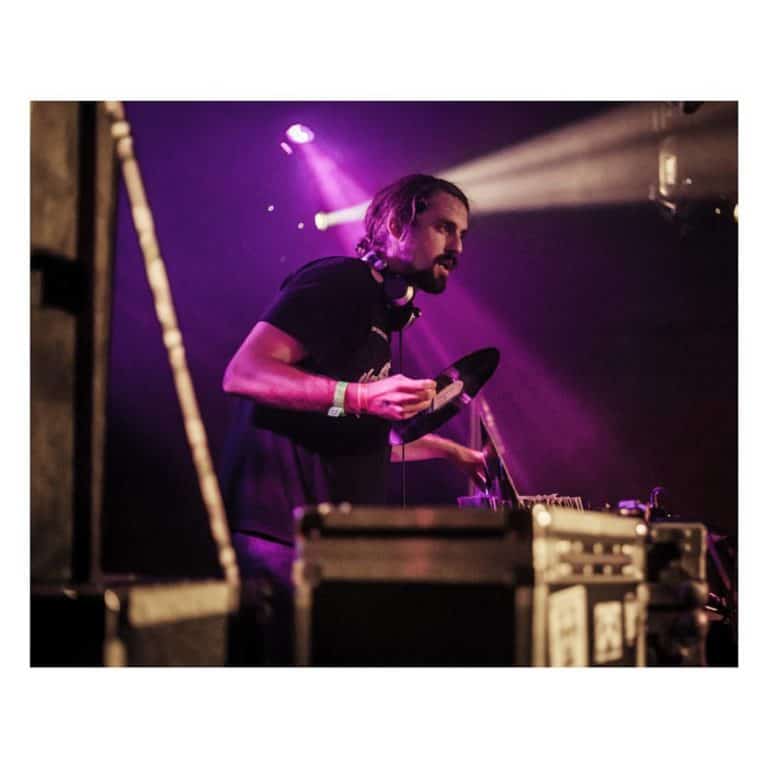 Soundfounder holding a record on stage, washed in haze and purple light