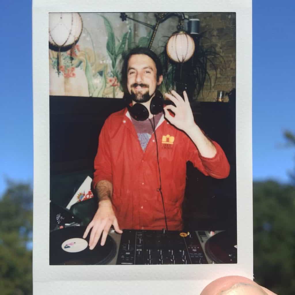young Soundfounder spinning tunes and smiling, captured in a polaroid