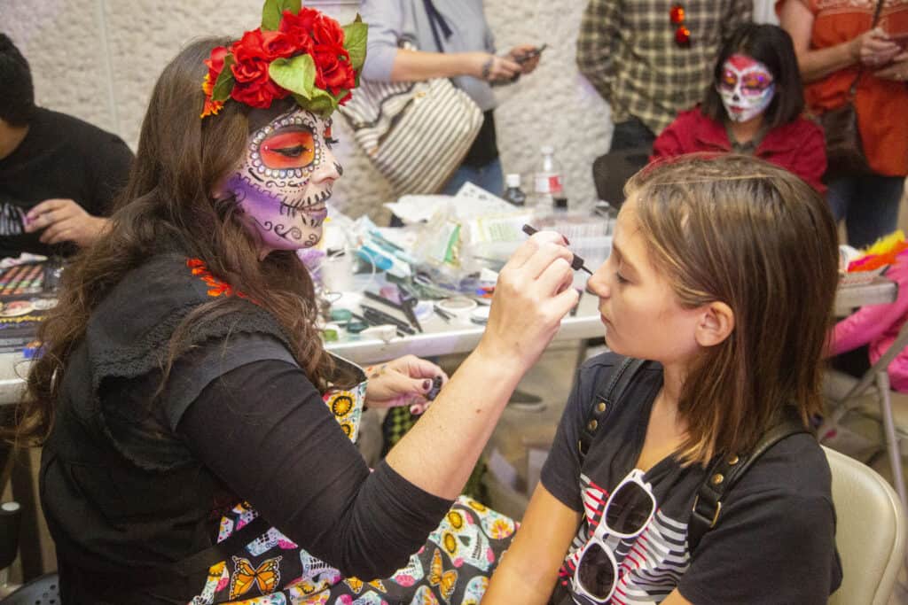 Day of the Dead 2019 at the MACC, Olivia painting faces. Photo by Ulises Garcia Vela